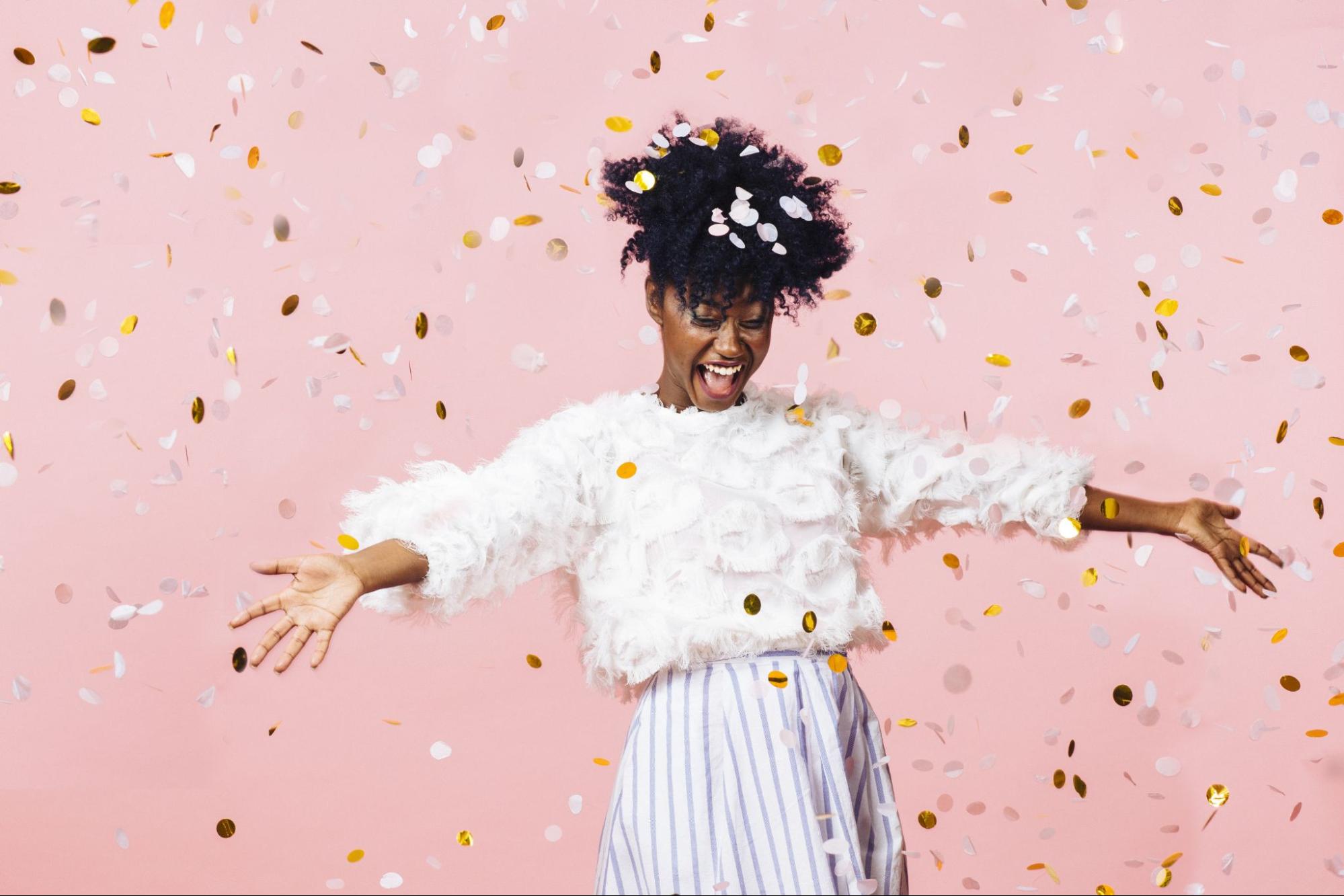A woman celebrating surrounded by confetti to represent Resolutions to Look Your Best