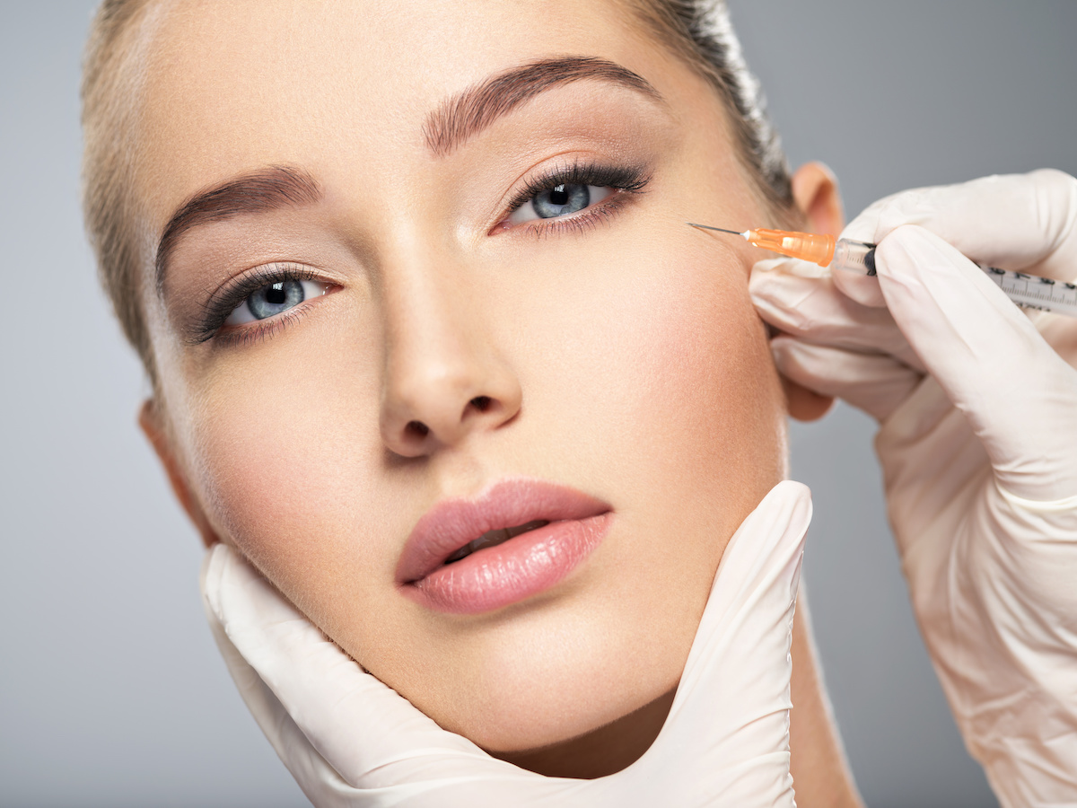 Woman getting cosmetic injection of botox in cheek / blog - myths about injectables